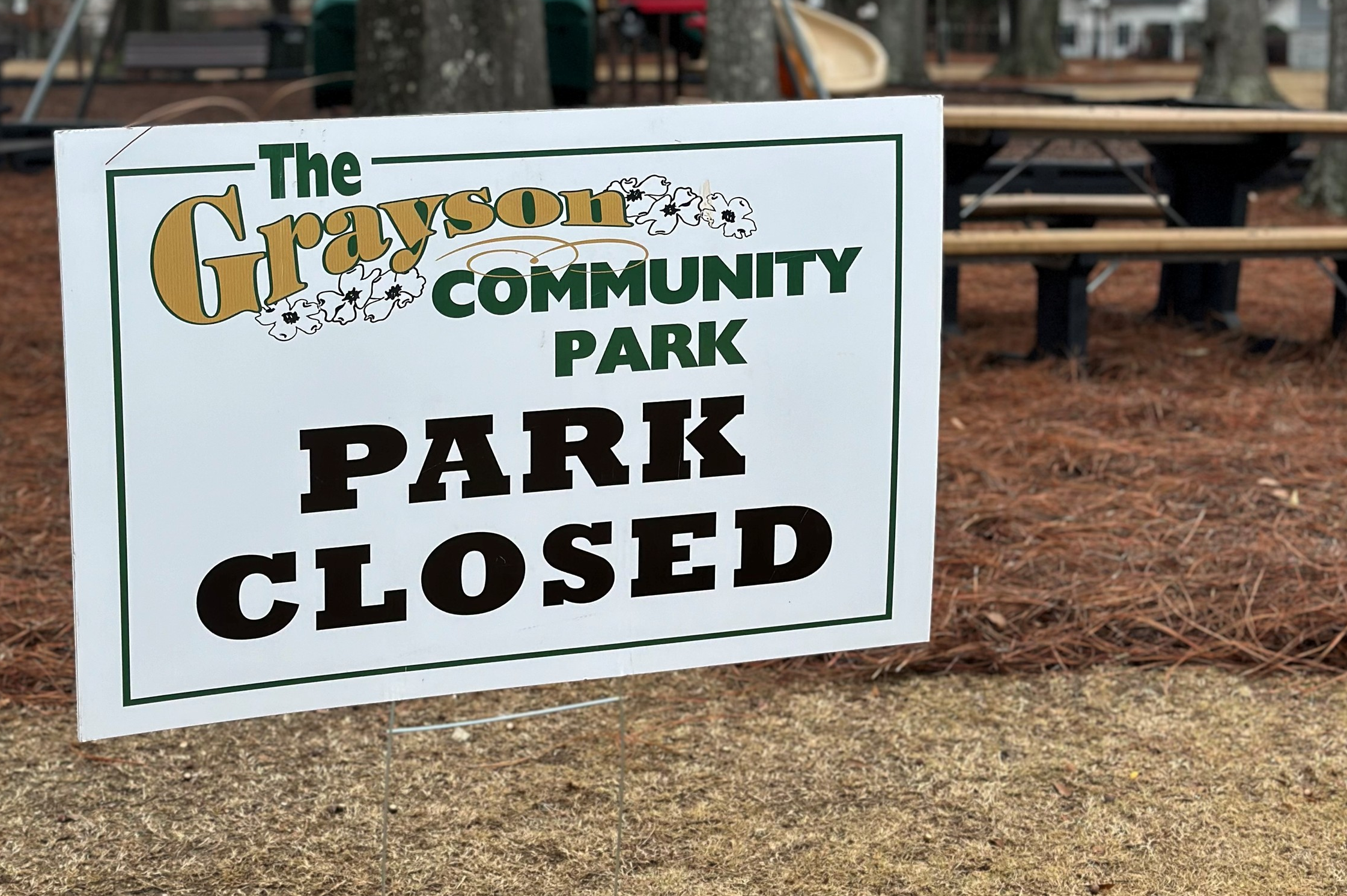Photo of sign with text reading Grayson Community Park Closed